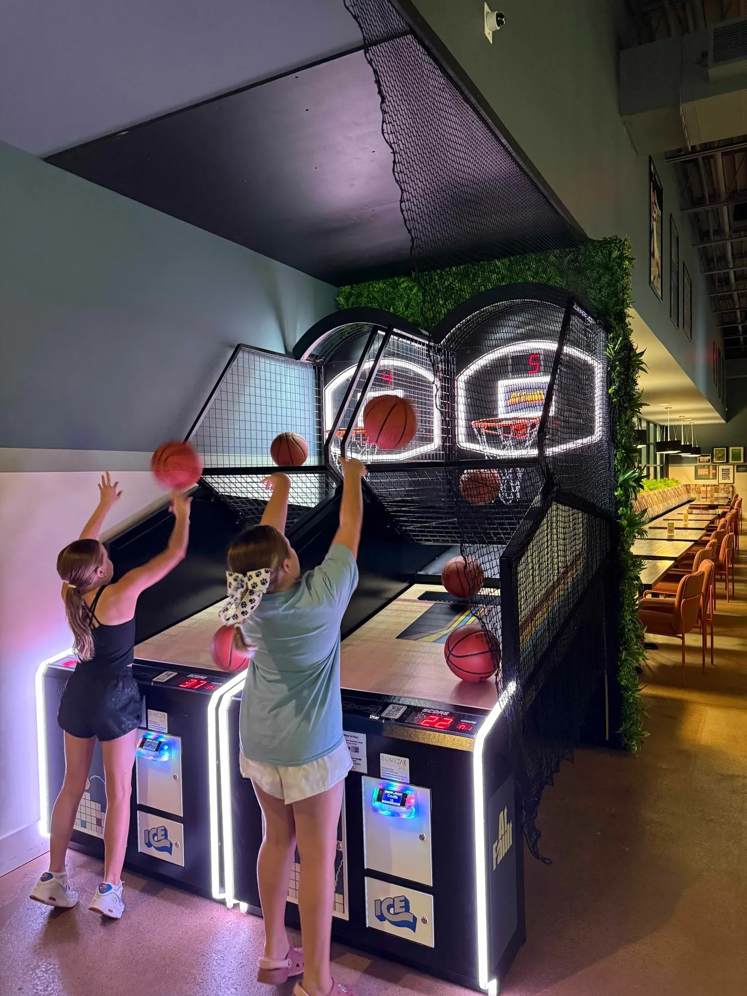 Guests playing basketball arcade games at At Fault
