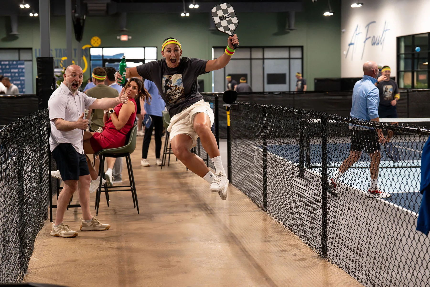 A guest celebrates courtside at At Fault during a private pickleball event